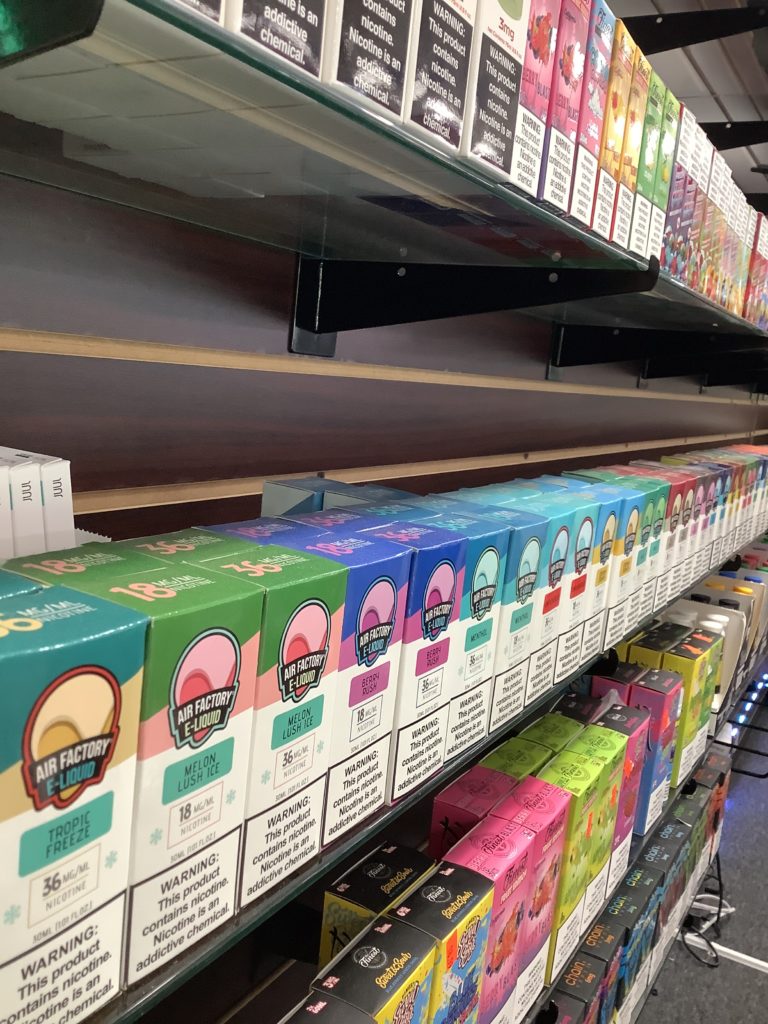 A shelf in a store filled with boxes of E-Liquids